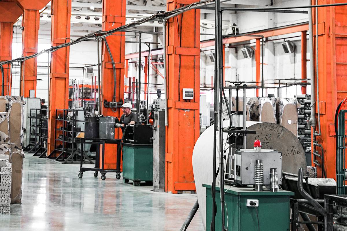 Nave industrial con maquinaria y un operario trabajando